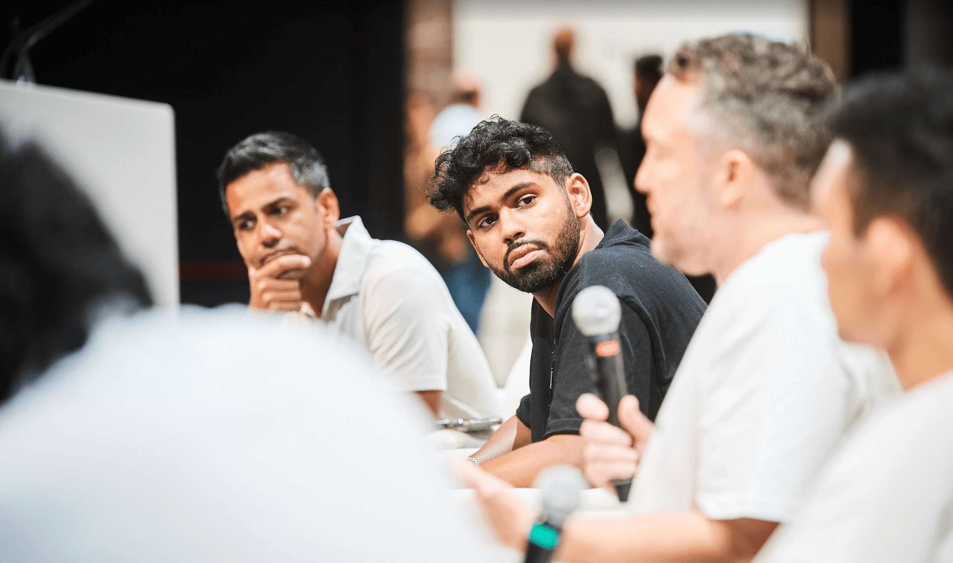 Speaker presenting on the main stage at an Open AGI Summit